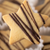 A star-shaped shortbread cookie drizzled with dark chocolate, held in front of a softly blurred background of similar cookies.