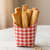 Cookie Fries sticks in a red and white checkered container on a marble surface
