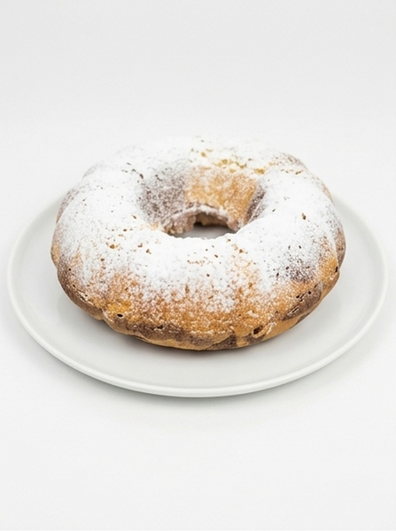 A bundt cake dusted with powdered sugar, served on a white plate against a clean white background.