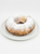 A bundt cake dusted with powdered sugar, served on a white plate against a clean white background.