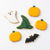 Six Halloween-themed sugar cookies decorated with icing on a clean white background. The cookies include yellow pumpkins, a white ghost, a green witch hat, and a black bat.