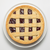 A top-down view of a freshly baked Linzer Torte with a lattice crust and dark red raspberry jam filling, served on a white ceramic plate against a clean white background.