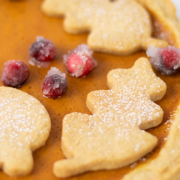 Close up of pumpkin mouse tart topping with shortbread cookies and cranberries