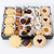 A black gift box filled with assorted cookies, with three pieces placed in front on a white background. 