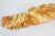 A traditional Austrian Easter bread with almonds sprinkled on top, sliced  on a white background.
