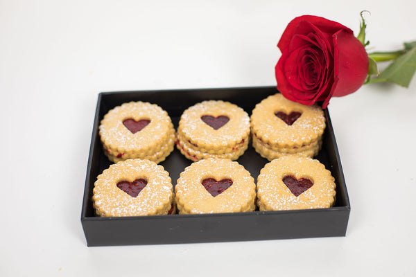 A box with Raspberry Linzer Hearts and Rose