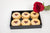 A box with Raspberry Linzer Hearts and Rose